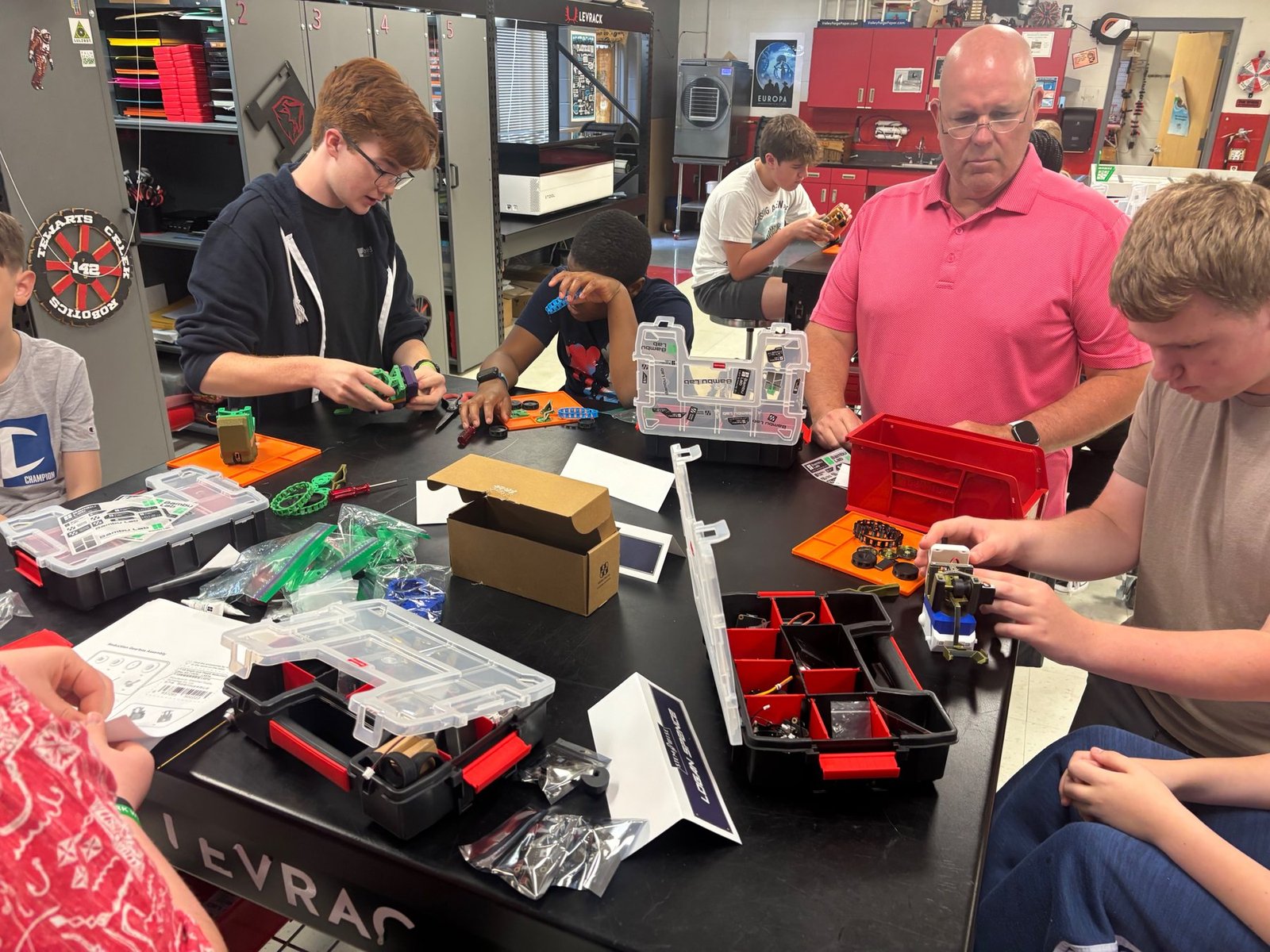 A STEMWISE instructor helping students build a robot at camp