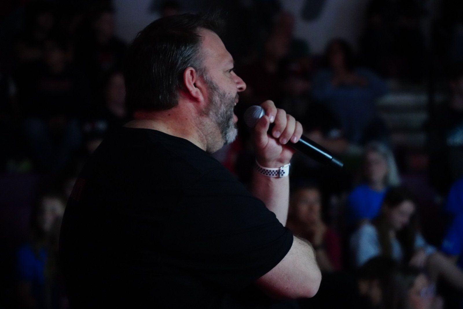 Kevin Welch speaking into a microphone at an event